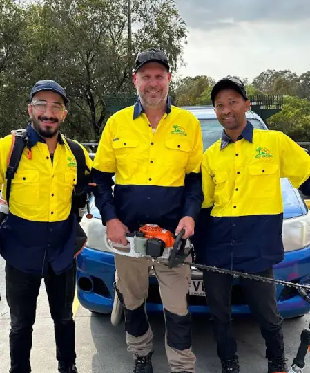 Friendly Oxley GPM garden maintenance crew posing with hedge trimmer and safety gear in Brisbane.